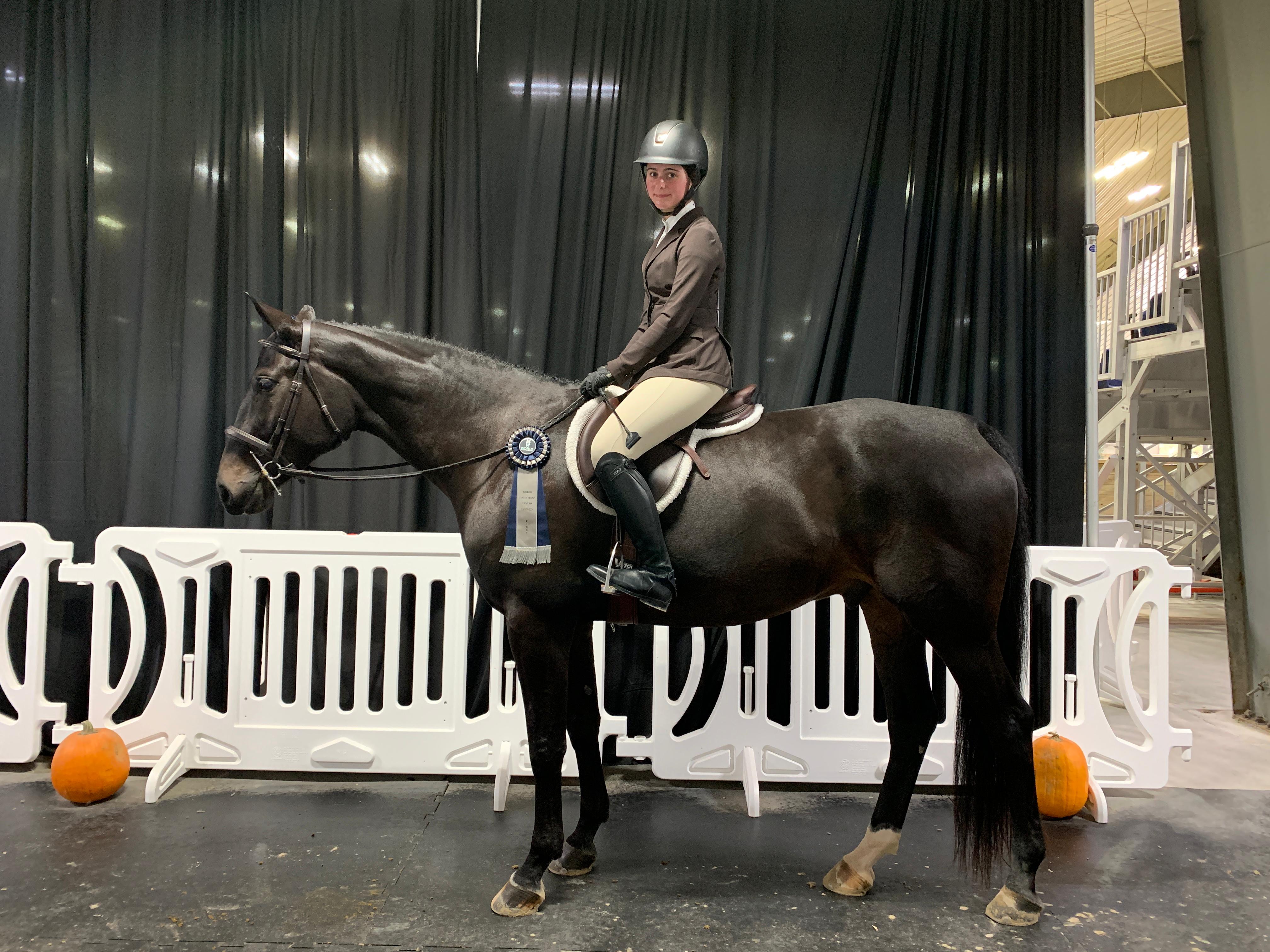 Chloe with a blue ribbon at an indoor show
